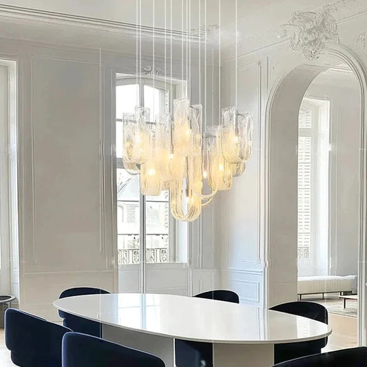 Modern dining room with a chandelier, round table, and chairs.