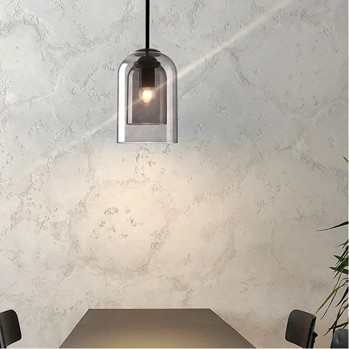 Modern pendant light with glass shade on a textured wall background