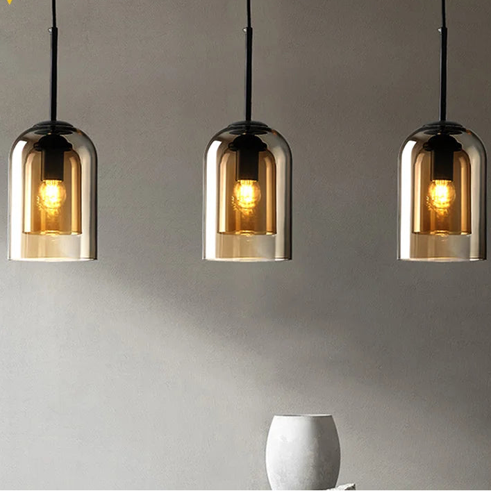 Three pendant lights with glass shades on a gray background