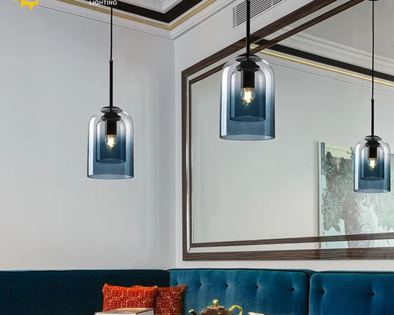 Modern interior design with blue pendant lights, a mirror, and a table with a teapot and cups.
